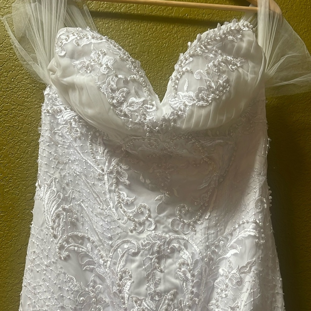 Small wedding dress,lots a bead work. Rich lace.
